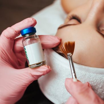 Esthetician applying a chemical peel treatment